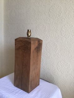 a wooden box sitting on top of a white tablecloth covered bed in a room