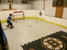 a young man is practicing his hockey skills on the ice at an indoor practice facility