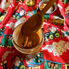 a spoon in a jar filled with liquid on top of a red tablecloth covered table cloth