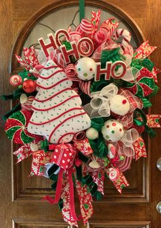 a christmas wreath on the front door decorated with holiday decorations and letters that spell ho ho