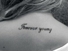 the back of a woman's neck with an inscription on it that says, forever young