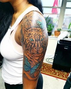 a woman with a tiger and butterfly tattoo on her arm