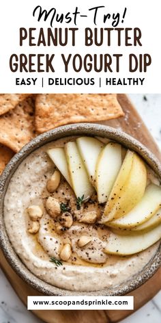 a bowl filled with peanut butter greek yogurt dip next to crackers and pita chips