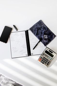 A notebook surrounded by a phone, pen, microfiber towel, and calculator. Teacher Essentials, Microfiber Towel, Calculator