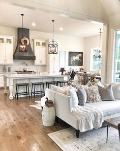 a living room filled with furniture next to a kitchen