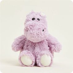 a purple stuffed animal sitting up against a white background