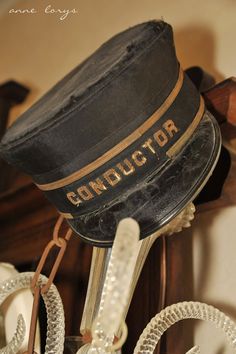 an old fashioned hat is hanging from a shelf with other items around it and the caption reads, conductor