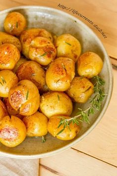 a bowl filled with cooked potatoes on top of a wooden table