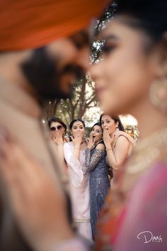 a group of women standing next to each other in front of a man and woman