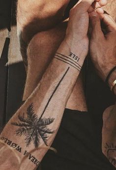 two people holding hands with palm trees on their arms and the words date tattooed on them