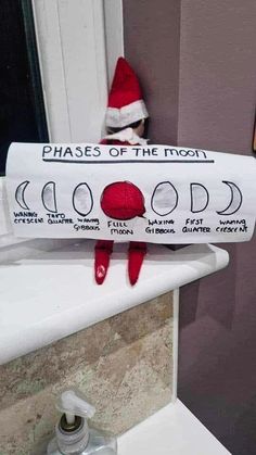 a toilet paper roll with the words phases of the moon on it and a red elf's hat