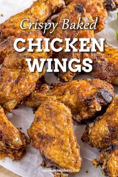 crispy baked chicken wings on a plate with lettuce and tomatoes in the background