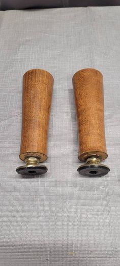 two wooden spools sitting on top of a bed