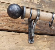 a close up of a metal hook on a wooden door with a ball hanging from it