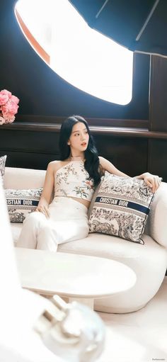 a woman sitting on top of a white couch