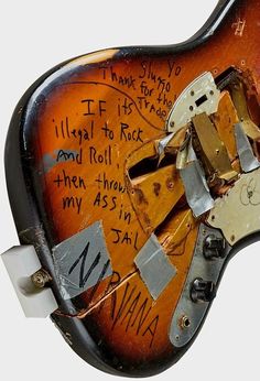 an electric guitar with many pieces of writing on the top and bottom of it's body