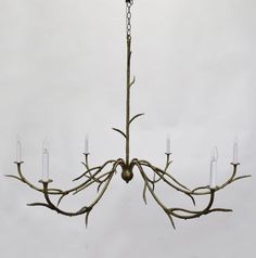 a chandelier made out of branches with candles hanging from the middle and bottom