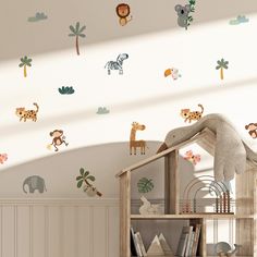 there are many animals on the wall in this child's room, including zebras and giraffes