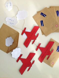 paper airplanes and clouds on brown envelopes, with string attached to the top one