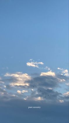 the sky is filled with clouds and birds flying in the distance on a sunny day