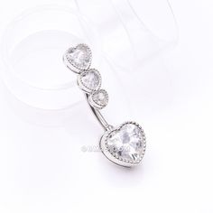 Show off your sparkling style with our Brilliant Sparkle Cascading Heart Drop Top Belly Button Ring. This stunning piece features a cascading heart design that will catch the light and dazzle all who see it. Add a touch of elegance and shine to any piercing with this belly ring. View All Colors/Styles Material: 316L Stainless Steel Size: 14 GA (1.6mm), 3/8" (10mm) Length: 1.1 inch (28mm) Width: 0.4 inch (9mm) Suitable for Navel Piercings It is always recommended to know your exact piercing size Silver Heart Belly Rings For Valentine's Day, Valentine's Day Silver Heart Belly Rings, Silver Belly Rings For Valentine's Day, Elegant Heart-shaped Internally Threaded Belly Rings, Elegant Heart-shaped Wedding Belly Rings, Navel Piercing, Belly Button Ring, Button Ring, Drop Top