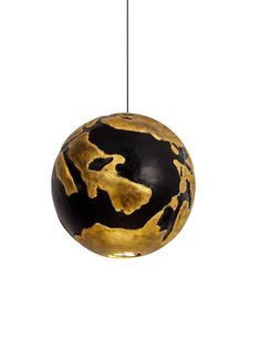 a black and gold ball ornament hanging from a string on a white background