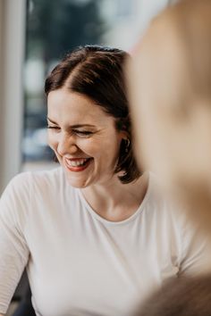 a woman laughing while looking at her cell phone