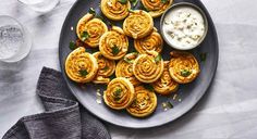 a plate full of rolls and dip on a table