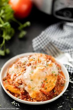 a white bowl filled with lasagna sauce and topped with parmesan cheese