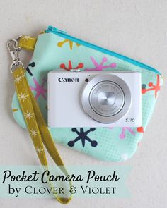 a camera sitting on top of a blue and green bag with a yellow lanyard