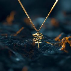 a gold necklace with an omen symbol hanging from it's center, on top of a rock