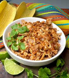 a white bowl filled with shredded meat and cilantro