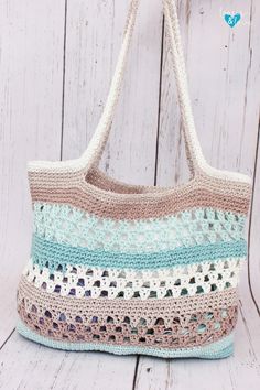 a crocheted bag hanging from a hook on a white wooden background with text overlay that says free crochet pattern