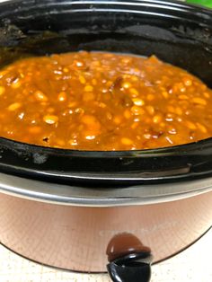 a crock pot filled with beans on top of a table