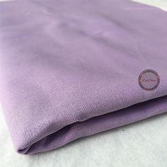 a close up of a purple cloth on a white tablecloth with the word logo