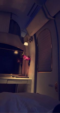 the interior of an airplane with a bed and desk in front of it at night