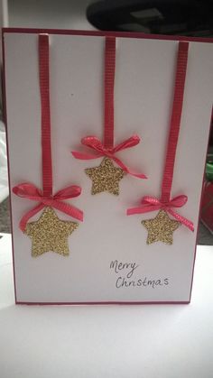 two christmas cards with gold stars and pink bows on them, one has a merry christmas message