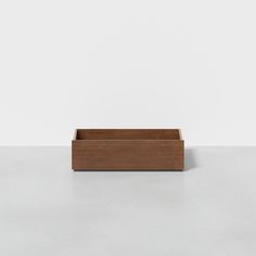 a wooden box sitting on top of a white table next to a gray wall and floor