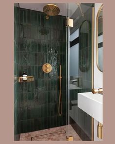 a green tiled bathroom with gold fixtures and shower faucet in the corner, along with a white sink