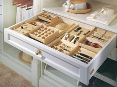 an open drawer on a white table filled with jewelry