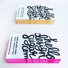 two business cards with black and pink ink on them