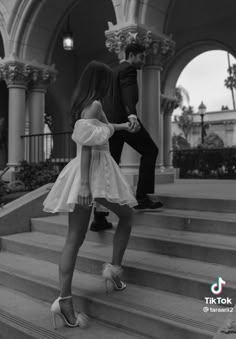 two people are standing on the steps in front of a building