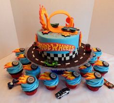 a birthday cake with cars on it and cupcakes