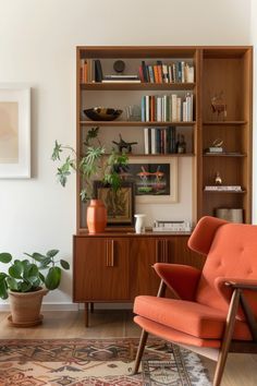 an orange chair sitting in front of a wooden book shelf filled with books and plants