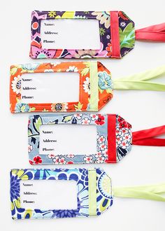 four tags with flowers on them sitting next to each other in front of a white background