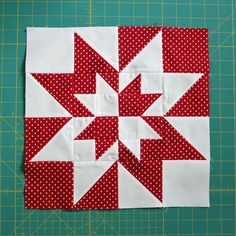 a red and white quilted block on a cutting board