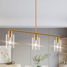 three lights that are hanging over a table