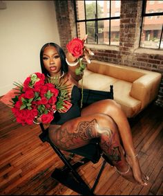 a woman sitting in a chair holding roses