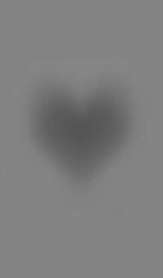 a black and white heart shaped object on a gray background with the light reflecting off it's left side