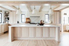 a large kitchen with wooden cabinets and white counter tops, along with an island in the middle